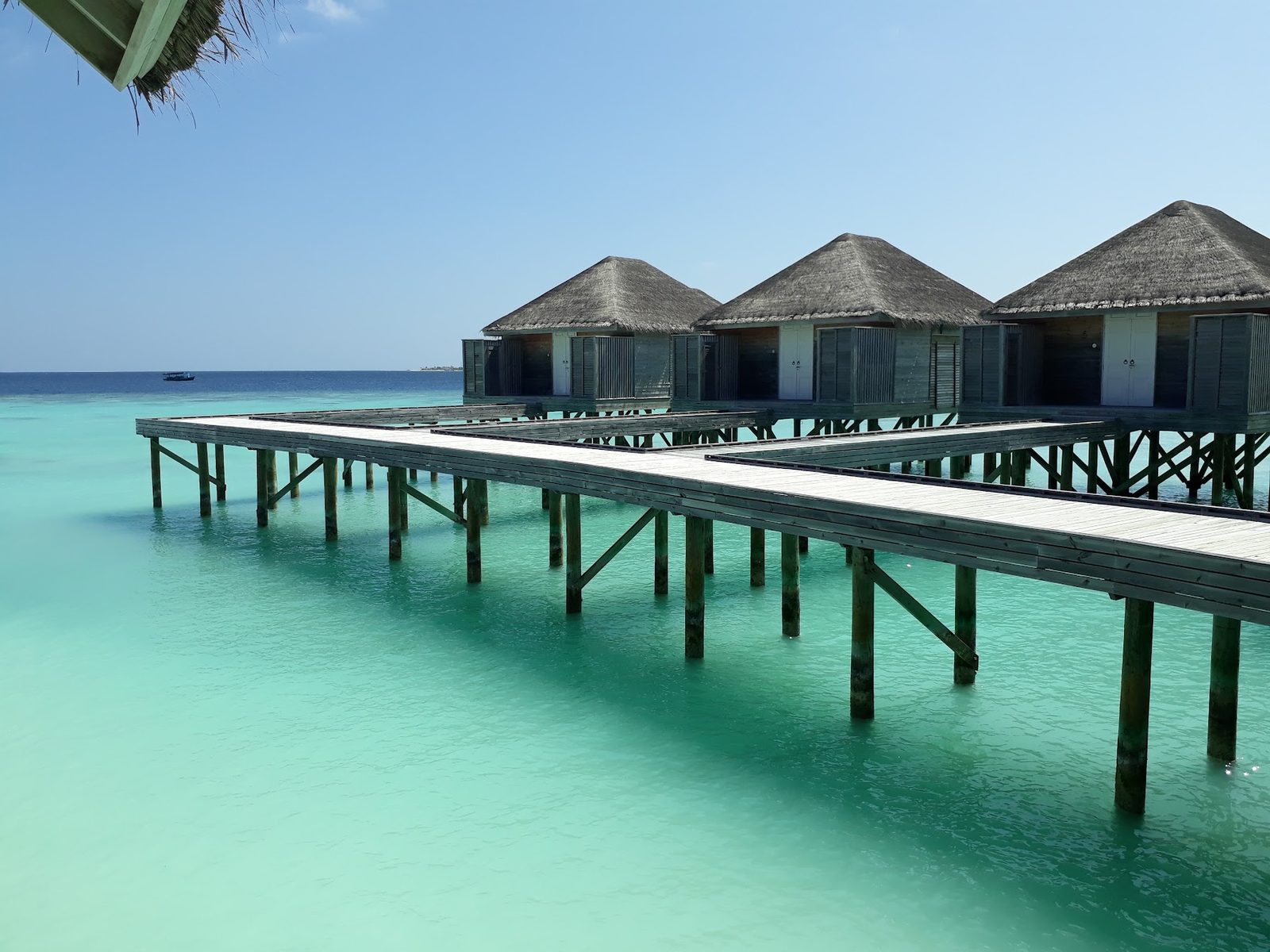 Overwater villas and timber jetty above a turquoise lagoon in the Maldives